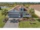 Single-story home with gray exterior, tile roof, and landscaped yard at 225 Daylily Blvd, Nokomis, FL 34275