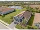 Aerial view of a single story home with a lake view in a residential community at 225 Daylily Blvd, Nokomis, FL 34275