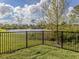 Fenced backyard with grassy area and pond view at 225 Daylily Blvd, Nokomis, FL 34275