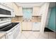 White appliances and mosaic backsplash in this well-lit kitchen at 3532 Lake Bayshore Dr # K117, Bradenton, FL 34205
