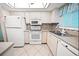 Efficient kitchen with white appliances and mosaic backsplash at 3532 Lake Bayshore Dr # K117, Bradenton, FL 34205