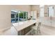 Kitchen island with seating area, white cabinets, and sliding glass doors to a pool area at 5910 Red Mangrove Ln, Bradenton, FL 34210