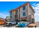 Under-construction home with large windows, unfinished exterior, construction vehicles, and a dumpster at 6489 Gulfside Rd, Longboat Key, FL 34228