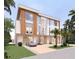 Modern two-story home with wood accents, large windows, manicured lawn, and driveway with a silver car at 6489 Gulfside Rd, Longboat Key, FL 34228