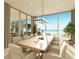 Ocean view dining room with large table and modern chandelier at 6489 Gulfside Rd, Longboat Key, FL 34228