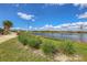 Landscaped walking path alongside a pond with fountain in a residential community at 7505 W Lenox Cir, Punta Gorda, FL 33950