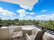 Comfortable balcony with seating offers stunning views of the cityscape and clear blue skies at 800 N Tamiami Trl # 307, Sarasota, FL 34236