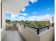 Relaxing balcony overlooking lush landscape and partial water view at 800 N Tamiami Trl # 307, Sarasota, FL 34236