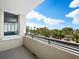 Balcony view overlooking a city with tall buildings, palm trees, and a bright blue sky with fluffy white clouds at 800 N Tamiami Trl # 307, Sarasota, FL 34236