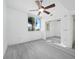 Clean, white bedroom featuring light grey floors, a ceiling fan, and a mirrored closet for ample storage at 800 N Tamiami Trl # 307, Sarasota, FL 34236