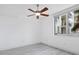 Bright bedroom with light gray floors, ceiling fan, and a window offering city and palm tree views at 800 N Tamiami Trl # 307, Sarasota, FL 34236