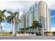 Exterior view of a high-rise building surrounded by lush landscaping and palm trees at 800 N Tamiami Trl # 307, Sarasota, FL 34236