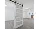 White barn door separating living and dining areas at 800 N Tamiami Trl # 307, Sarasota, FL 34236