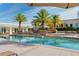 Resort-style swimming pool surrounded by lounge chairs, palm trees, and building in the background at 800 N Tamiami Trl # 307, Sarasota, FL 34236