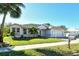 White house with a red door and lush green landscaping at 818 Oak Pond Dr, Osprey, FL 34229