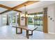 Bright dining room with large sliding doors, wood beam ceiling, and a rustic wooden table at 13148 Bliss Loop, Bradenton, FL 34211