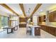 Modern kitchen with island, custom cabinetry, and exposed wooden beams at 13148 Bliss Loop, Bradenton, FL 34211