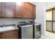Laundry room with washer, dryer, cabinets, and utility sink at 13148 Bliss Loop, Bradenton, FL 34211