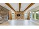 Spacious living room featuring a log wall accent and exposed wood beams at 13148 Bliss Loop, Bradenton, FL 34211