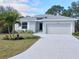 Curb appeal abounds with this charming new construction home, featuring a two-car garage and manicured lawn at 160 Apollo Dr, Rotonda West, FL 33947