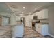 Spacious kitchen features a granite island, stainless steel appliances and gray wood-look tile flooring at 160 Apollo Dr, Rotonda West, FL 33947