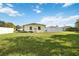 Back exterior of house showing light yellow siding and a grassy yard at 2057 Garden Pkwy, Bradenton, FL 34205