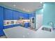 Modern kitchen with blue cabinets, stainless steel appliances, and white quartz countertops at 228 36Th Ne St, Bradenton, FL 34208