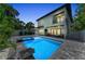 Backyard featuring a luminous pool, contemporary landscaping, and a view of the modern home at 2425 Floyd St, Sarasota, FL 34239
