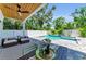 Outdoor space showcasing a clear pool, covered patio with fan, and beautifully landscaped surroundings at 2425 Floyd St, Sarasota, FL 34239