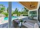 Outdoor living area with a sparkling pool, shaded patio, and elegant furniture for relaxation at 2425 Floyd St, Sarasota, FL 34239