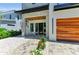 Contemporary home showcasing a covered entryway with stone accents, wood detailing, and a modern glass front door at 2425 Floyd St, Sarasota, FL 34239