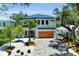 Charming two-story home showcasing a modern design, manicured landscape, and a wooden garage door at 2425 Floyd St, Sarasota, FL 34239