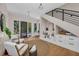 Sunlit foyer boasts hardwood floors, modern light fixtures, and stylish seating, plus staircase access at 2425 Floyd St, Sarasota, FL 34239