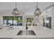 Modern kitchen with a large island, stainless steel sink, and a view of the pool area at 2425 Floyd St, Sarasota, FL 34239