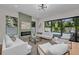 Bright living room with light hardwood floors, stylish fireplace, modern furniture, and pool views at 2425 Floyd St, Sarasota, FL 34239