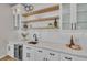 Wet bar with white cabinetry, open shelves, stylish fixtures, and a beverage refrigerator at 2425 Floyd St, Sarasota, FL 34239