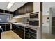 A galley style kitchen with dark wood cabinets, stainless steel appliances, and a microwave at 2711 W Marion Ave, Punta Gorda, FL 33950