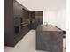 Modern kitchen with dark cabinetry, stainless steel appliances, and a large island at 4950 Remington Dr # 407, Sarasota, FL 34234