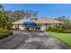 Single-story home with a blue awning and landscaping at 5502 Garden Lakes Oak, Bradenton, FL 34203