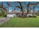 One-story house with white exterior and large oak trees at 5502 Garden Lakes Oak, Bradenton, FL 34203