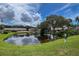 Community pond with lush landscaping and view of buildings at 6016 28Th W St # 6016, Bradenton, FL 34207