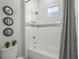 Bathroom with a tiled shower and tub, decorative mirrors, and a water-efficient toilet at 8332 Sea Glass Ct, Sarasota, FL 34240