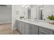 Bathroom featuring double vanity with gray cabinets, quartz countertop, and decorative pendant lighting at 8332 Sea Glass Ct, Sarasota, FL 34240