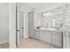 Bright bathroom featuring sleek gray cabinets, dual sinks, and a large frameless glass shower enclosure at 8332 Sea Glass Ct, Sarasota, FL 34240
