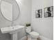 Powder room featuring a vessel sink, round mirror, stylish decor, and energy-efficient toilet at 8332 Sea Glass Ct, Sarasota, FL 34240