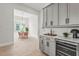 Elegant dining area with a wine fridge, custom cabinetry, and open view of the adjacent dining space at 8332 Sea Glass Ct, Sarasota, FL 34240
