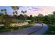 Picturesque entrance with lush landscaping, fountain, and paved driveway at 8332 Sea Glass Ct, Sarasota, FL 34240