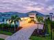Elegant home showcasing a beautifully paved driveway, lush landscaping, and a charming facade under a twilight sky at 8332 Sea Glass Ct, Sarasota, FL 34240