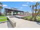 Exterior view of community clubhouse showing covered patio and beautiful landscaping at 8332 Sea Glass Ct, Sarasota, FL 34240