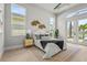 Bright main bedroom featuring a view of the yard, patterned rug, and bedside tables at 8332 Sea Glass Ct, Sarasota, FL 34240